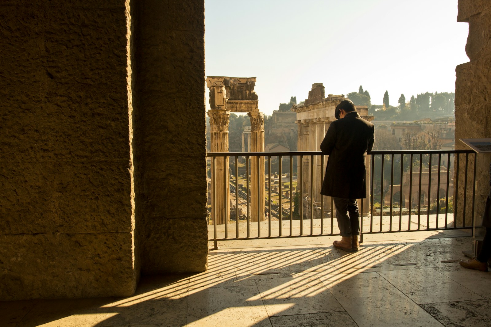 A visitor overlooking ancient Roman Forum ruins